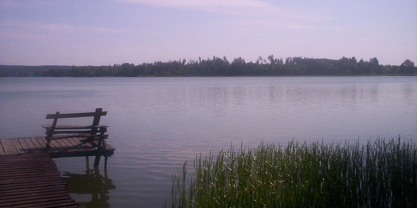 An image of Kalwa Lake with calm waters and surrounding greenery, showcasing lakes in Thane.