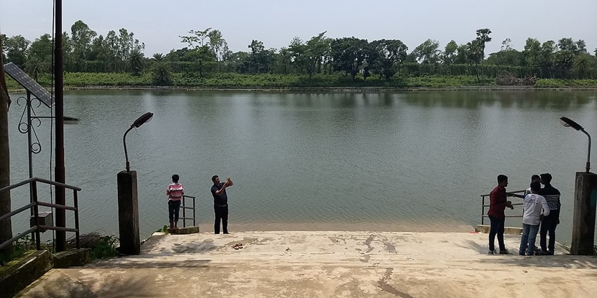 Kamala sagar lake with steps leading to the lake and people standing on both sides