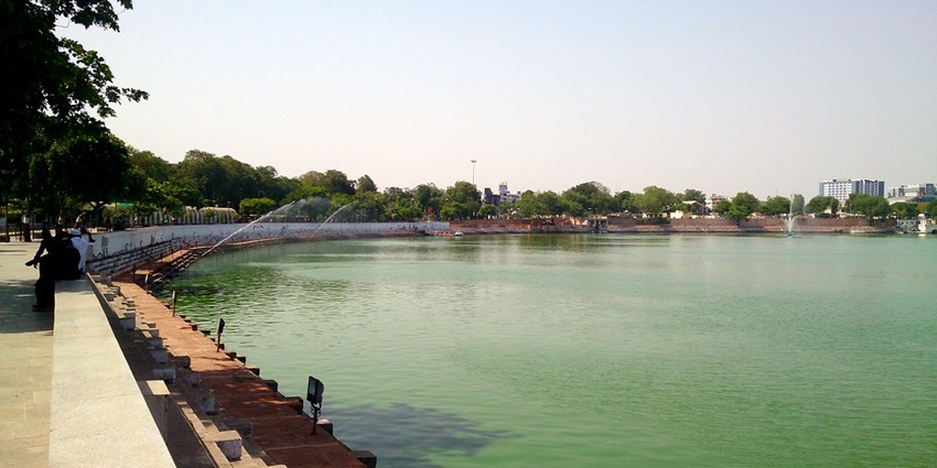 Lakes in Ahmedabad are peaceful with birds flying over giving a serene vibe.