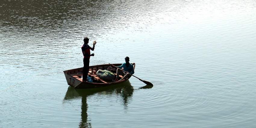 An image of Karan Tal lake in Haryana, India with clear waters and temple surroundings.