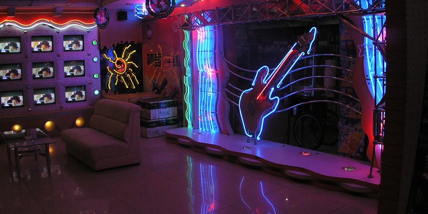 Stylish karaoke lounge featuring colorful neon lights and a sleek sound system, a must-visit for Tokyo nightlife