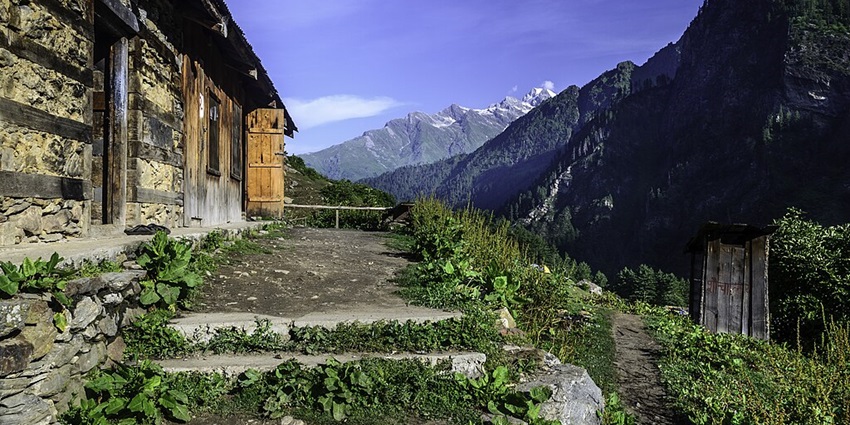 An image of the landscape in Kheerganga in Himachal Pradesh, with snow-capped mountains.