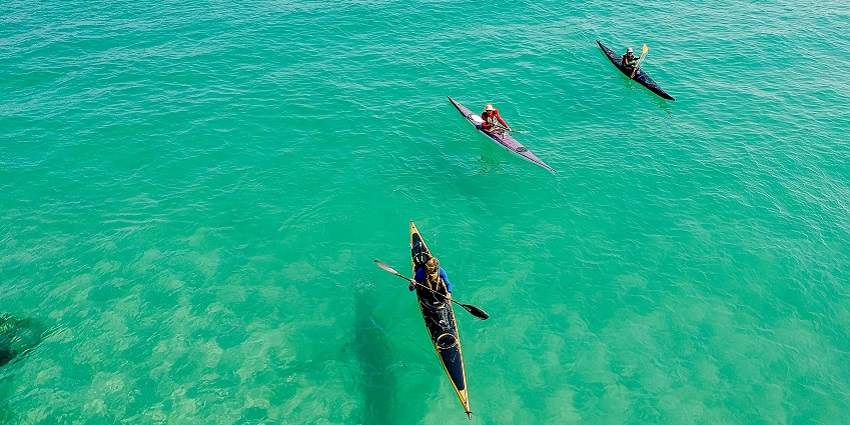 An image of people kayaking on a serene lake, one of the best water sports in Lonavala.