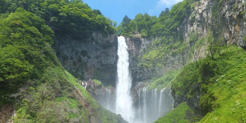 Majestic waterfall cascading down rocky cliffs in Nikko National Park.