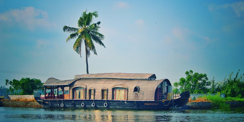 An image of a houseboat with a thatched roof in Kerala, one of the best places to visit in Christmas in India.
