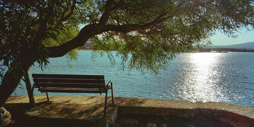 A picture of Khandarani Lake with calm waters surrounded by dense green hills.