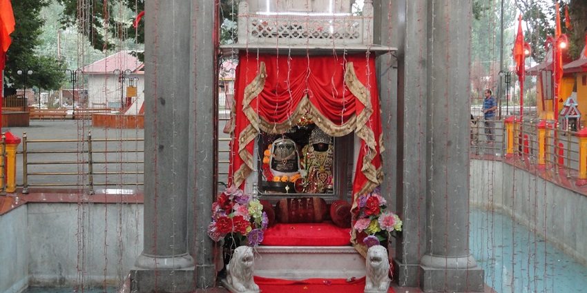 Kheer Bhawani temple with deity altar covered in multiple lights hanging from the pillars.
