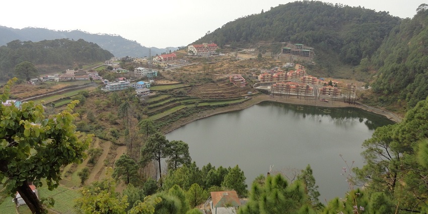 An image of Khurpatal Lake in Uttarakhand, surrounded by lush green hills