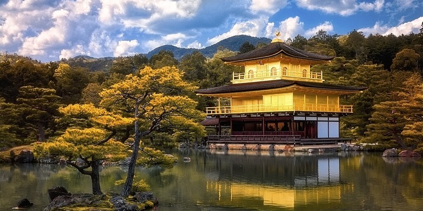 The golden Kinkaku-ji Temple, a famous Japanese temple, mirroring in a tranquil pond.