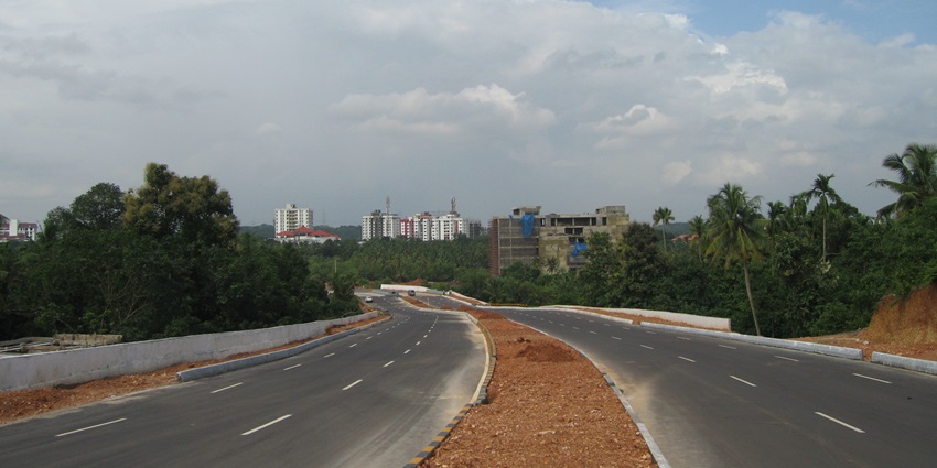 An image of the Kochi highway surrounded by greenery, one of the most popular road trips in South India.
