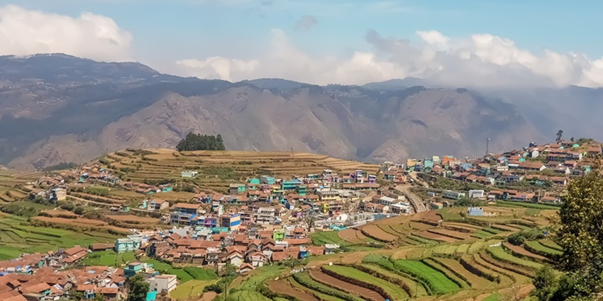 An image of a serene mountain view of Kodaikanal with terrace farming on the steps