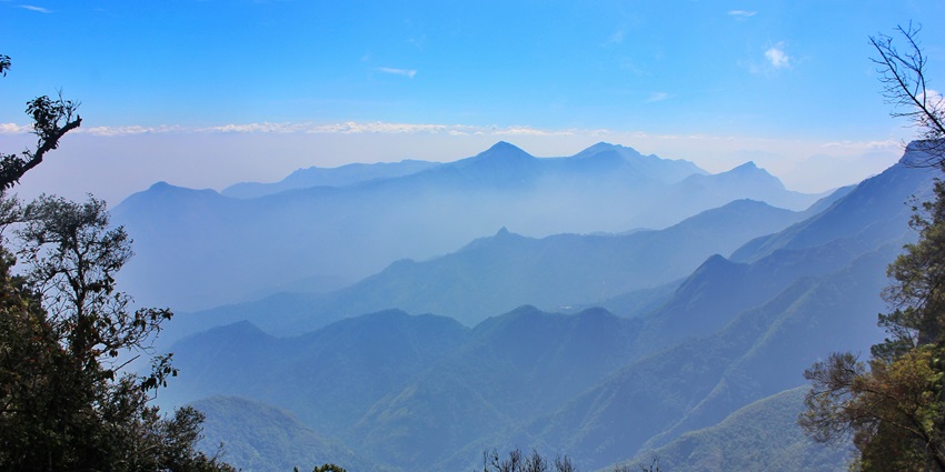 An image showing a view of Kodaikanal with a blue sky and surrounding landscape.