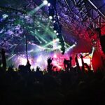 A view of a club of the region featuring a lively crowd and shimmering neon lights.