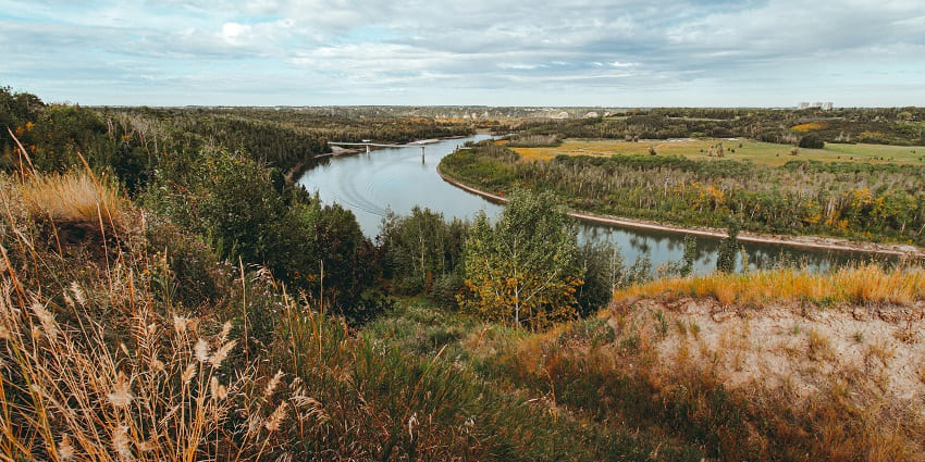 Image of a river valley with beautiful greenery and yellow trees surrounded under blue sky