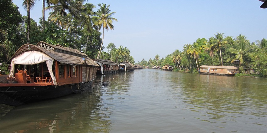 An image of houseboats on a calm river - one of the popular places to visit in October in India for couples