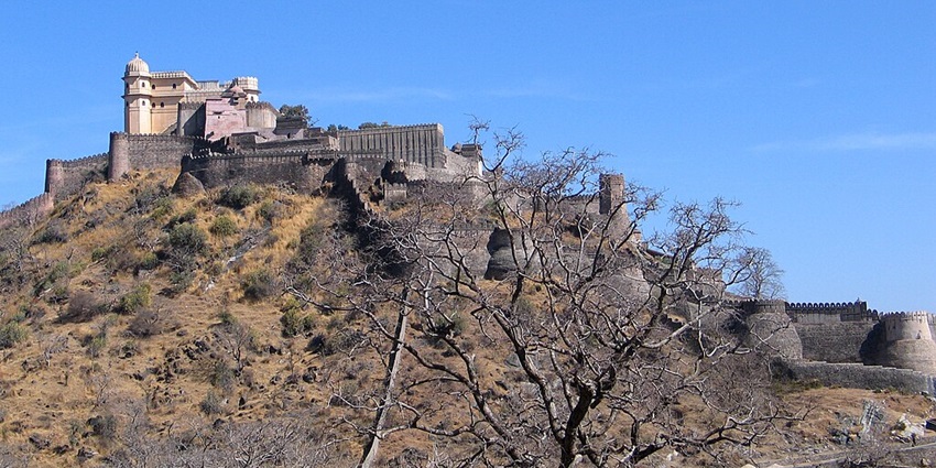 An image of the Kumbhalgarh fort on a hill, featuring high walls and stone structures