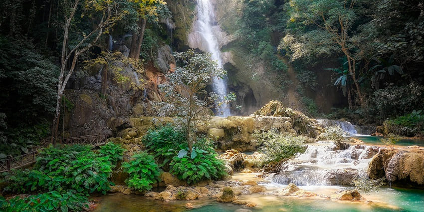 An image showing a waterfall surrounded by green plants, resembling the Kunchikal Falls.