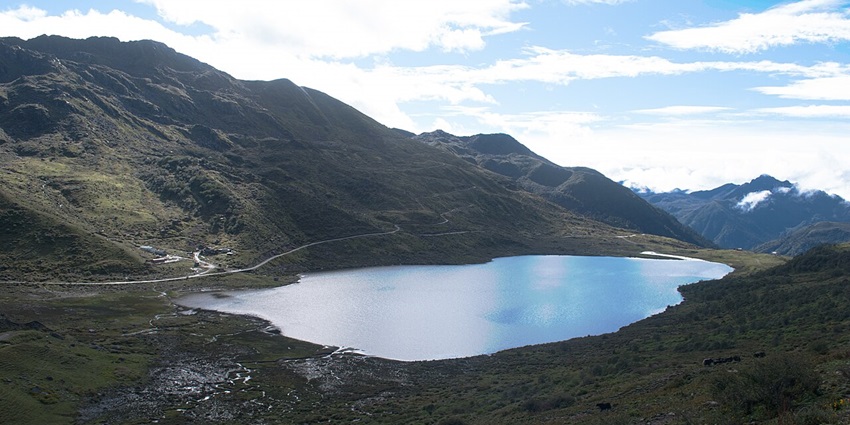 An aerial view of Kupup Lake nestled amid lush green hills from all directions in Sikkim.