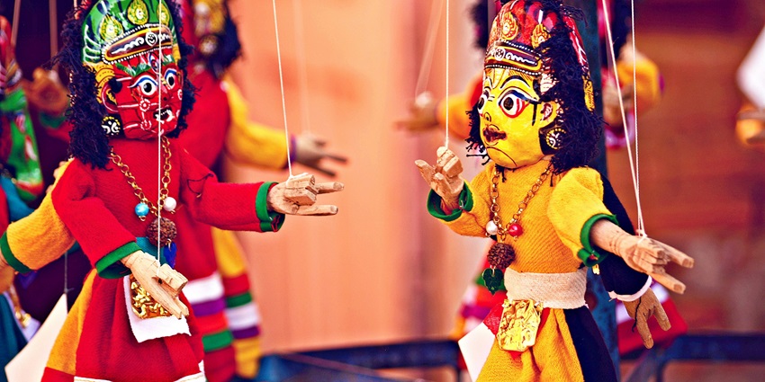 Colourful handmade puppets hanging in the shop that people can buy while shopping in Kutch.