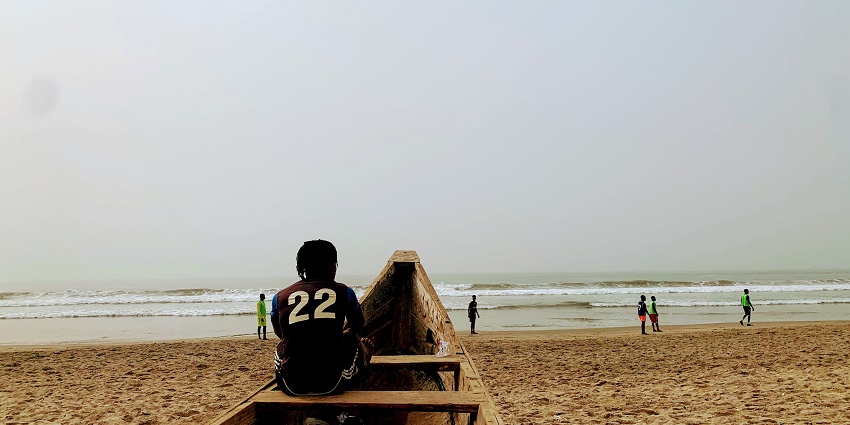 A man sits on a docked boat at the Labadi Beach in Ghana’s Greater Accra Region