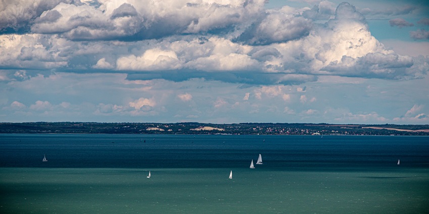 An image of Lake Balaton, Hungary, showcasing its vast blue waters and scenic surrounding landscape.