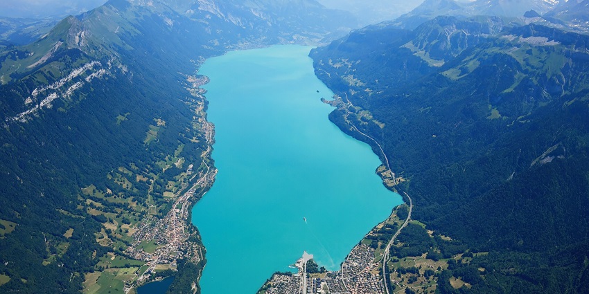 An image view of Brienz Lake in Switzerland with turquoise waters, surrounding mountains, and a scenic aerial perspective