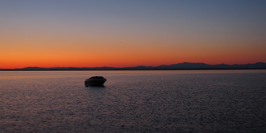 An image of Lake Champlain, a lake in the USA, with calm waters and a scenic Vermont backdrop.