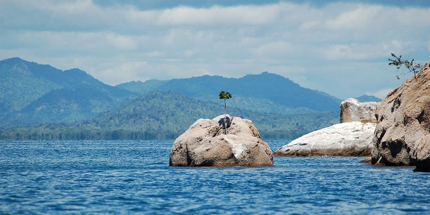 An image view of Lake Malawi with canoes floating on clear waters, reflecting lakes in Africa