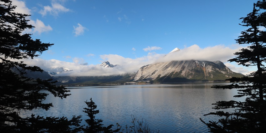 The panoramic view of the Lake of No Return, surrounded by lush green mountains.