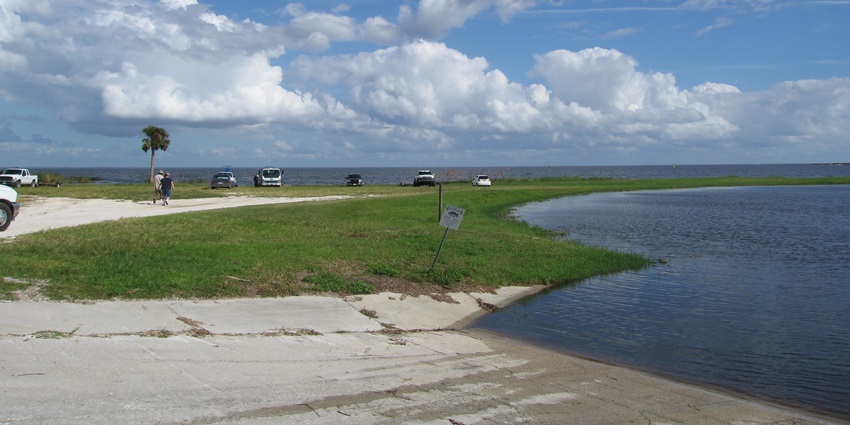 An image of Lake Okeechobee, a lake in the USA, with vast waters and a grassy shoreline.