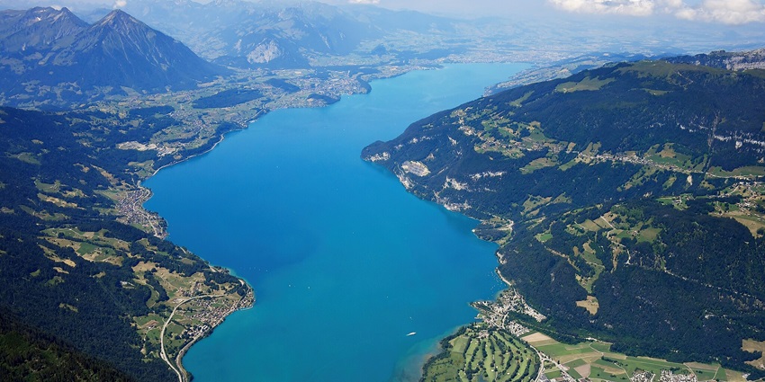 An image view of Thun Lake in Switzerland with deep blue waters, surrounding mountains