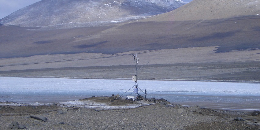 Frozen Lake Vida with a small satellite tower in the corner and mountains in the back
Viewers of this file can see comments and suggestions