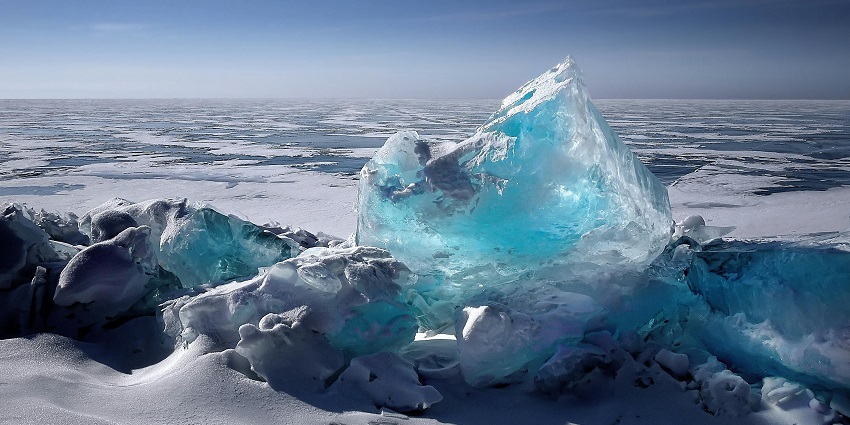 Buried frozen lake covered with thick white ice and a unique glass ice formation