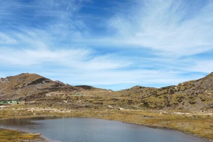 One of the lakes in Arunachal Pradesh, featuring pristine water, is surrounded by lush greenery and mountains.