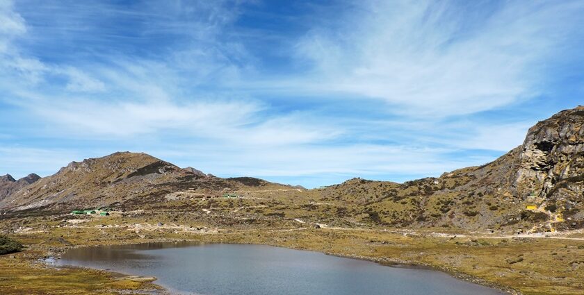 One of the lakes in Arunachal Pradesh, featuring pristine water, is surrounded by lush greenery and mountains.