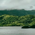 View of a calm lake surrounded by green mountains, one of the pretty lakes in Dominica.