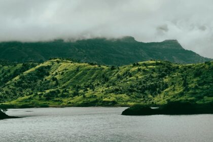 View of a calm lake surrounded by green mountains, one of the pretty lakes in Dominica.