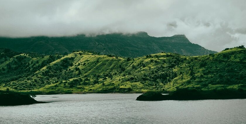 View of a calm lake surrounded by green mountains, one of the pretty lakes in Dominica.