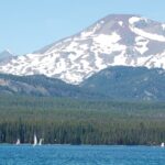 A couple paddles while boating in Oregon’s Elk Lake with South Sister in the background.