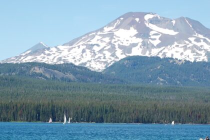 A couple paddles while boating in Oregon’s Elk Lake with South Sister in the background.