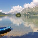 An image view of Sils lake in Switzerland with clear blue waters, mountains, and a scenic landscape