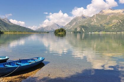 An image view of Sils lake in Switzerland with clear blue waters, mountains, and a scenic landscape