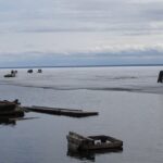 The largest lake in Canada with ruined wood and broken pieces lying on the shore.