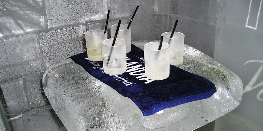 Drinks served on an ice table, creating a unique experience in a frozen setting.