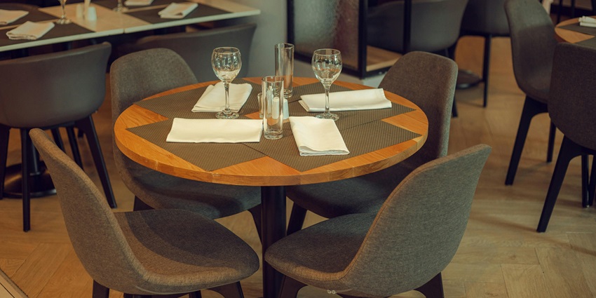 Elegant dining table with wine glasses, cutlery, and napkin on white tablecloth