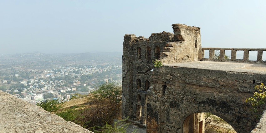 An image of the Chittorgarh fort overlooking a town with a hazy sky in the background