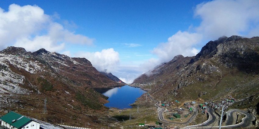 Tsomgo Lake from far away with a small water body surrounded by sandy shorelines