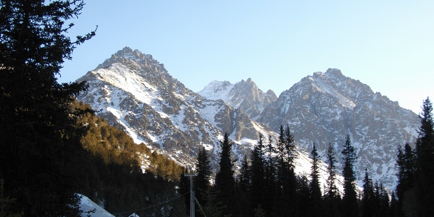 A majestic building stands in front of the mountains in Ala Archa National Park, Kyrgyzstan.
