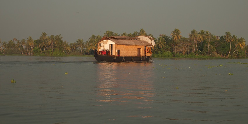 A peaceful houseboat on Vembanad Lake, the Largest Lake in India, reflecting golden hues