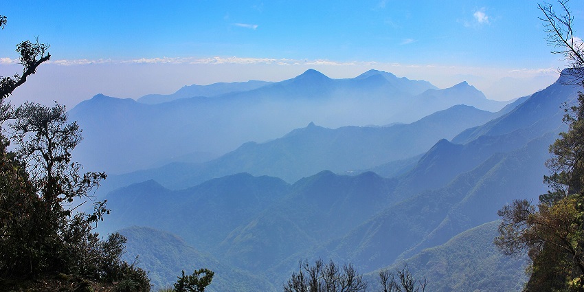 Trails of mountains with protruding peaks through layers of mist in Kodaikanal, Tamil Nadu